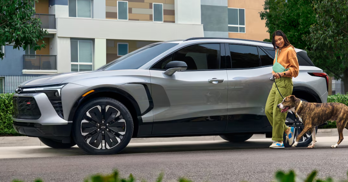 image of a parked 2025 Blazer EV and a woman walking her dog